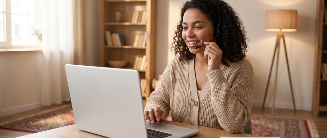 A counsellor dictating notes by headset into practice management software on a Windows laptop in a home consulting room
